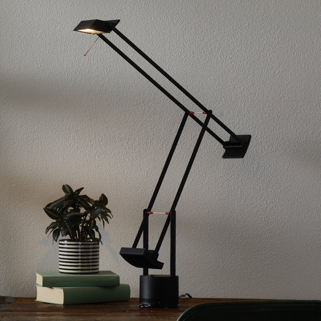Artemide Tizio 35 auf einem Schreibtisch mit Büchern und Pflanze
