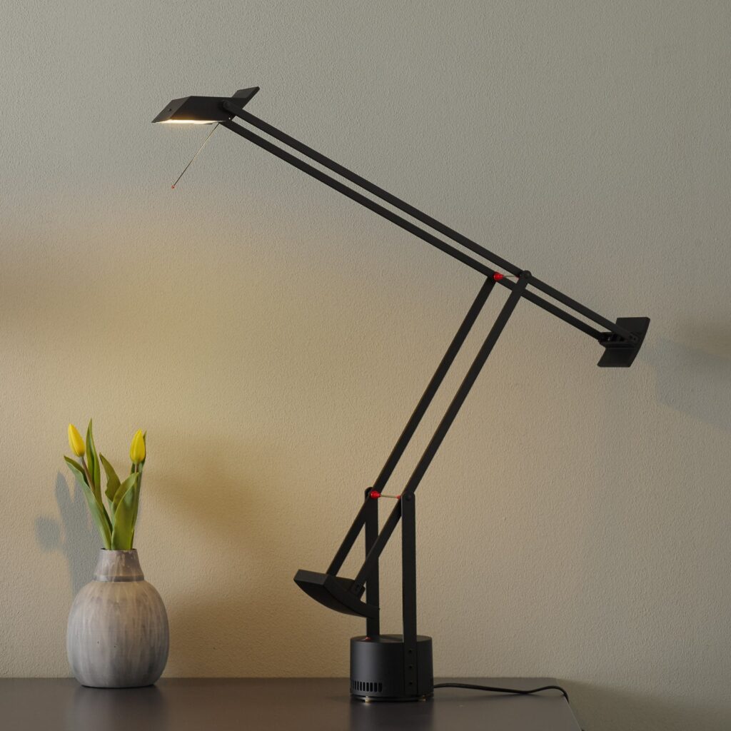 Artemide Tizio LED in Schwarz auf einem Schreibtisch mit Tulpen