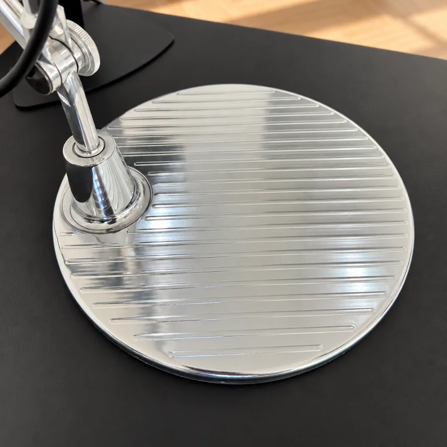 Runder Aluminiumfuß der Artemide Tolomeo mit gerillter Oberfläche auf einem Schreibtisch