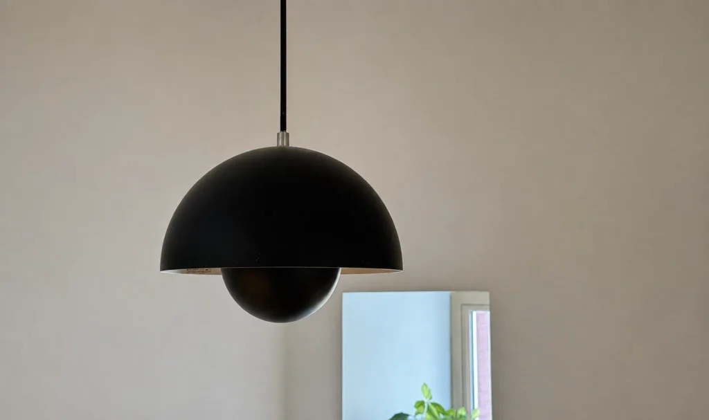 Mattschwarze &Tradition Flowerpot VP1 Pendelleuchte vor heller Wand