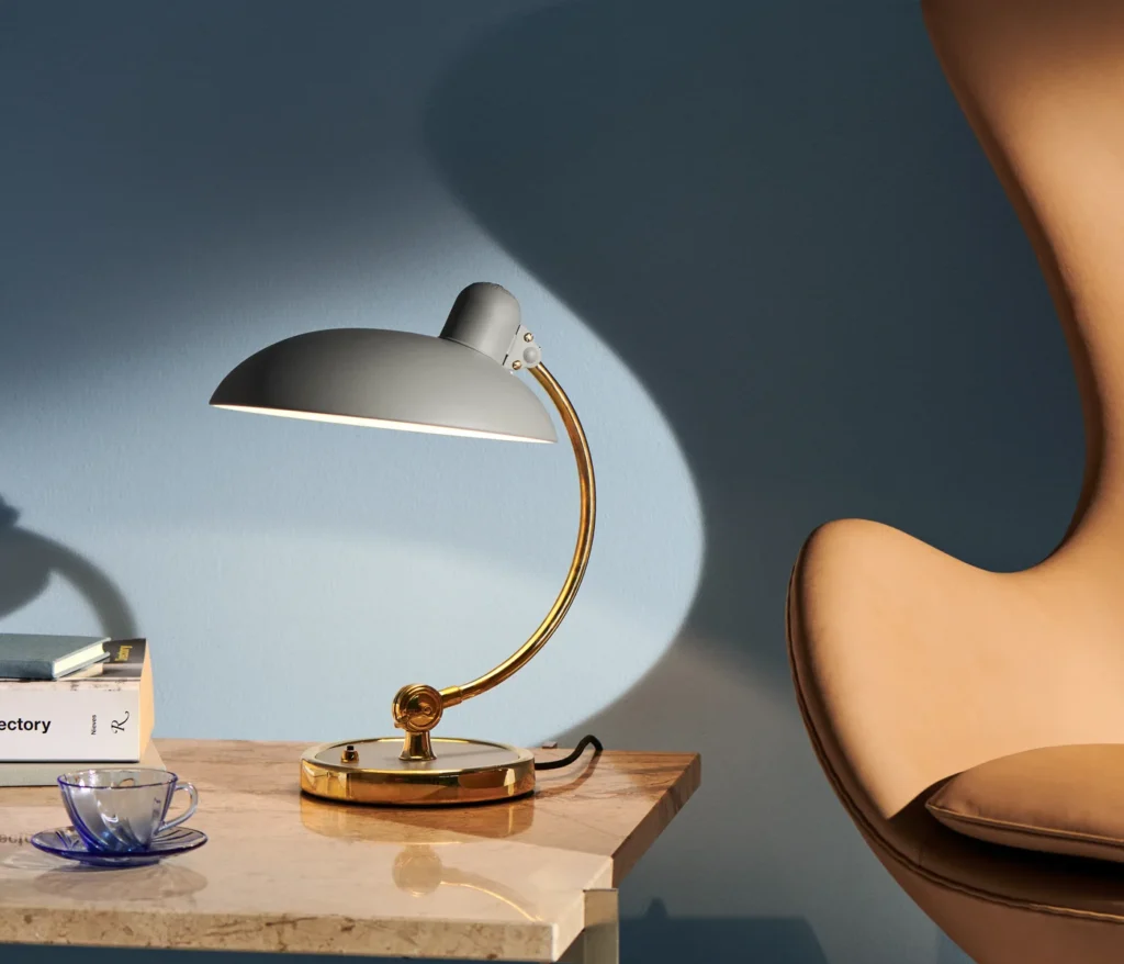 Fritz Hansen Kaiser Idell 6631 T Luxus in Hellgrau auf einem Marmortisch vor blauer Wand
