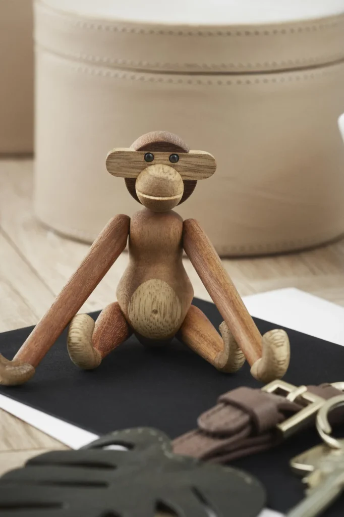 Kay Bojesen Affe Mini aus Teak und Limbaholz auf einem dunklen Untergrund