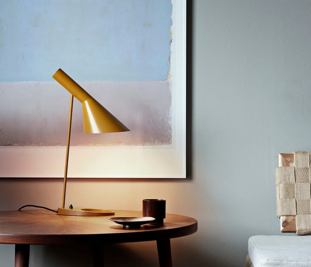 Louis Poulsen AJ Tischleuchte von Arne Jacobsen als skandinavischer Designklassiker auf Holztisch