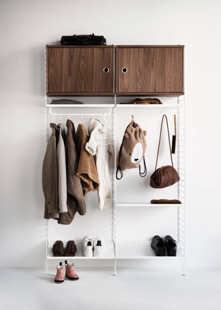 String System als Garderobe mit weißen Leitern, Kleiderstange, Schuhböden und Schränken in Nussbaum
