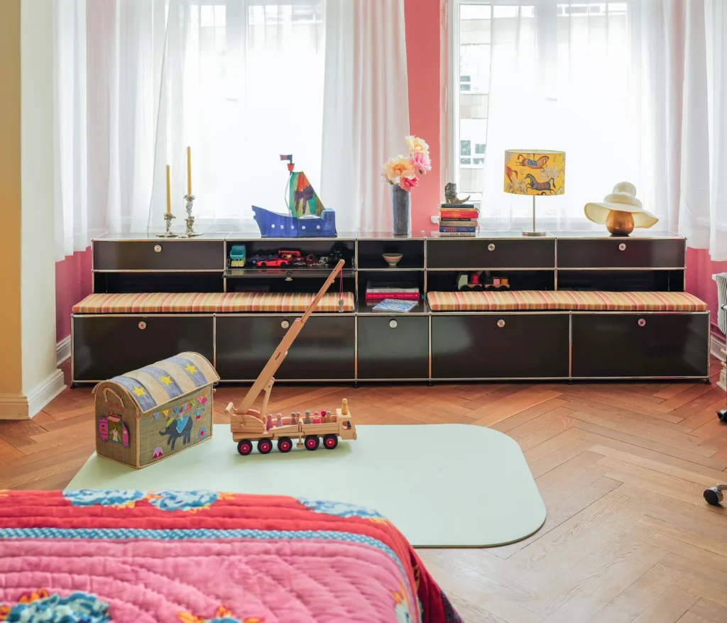 Langes USM Haller Lowboard unter Fenstern in einem Kinderzimmer mit rosa Wand