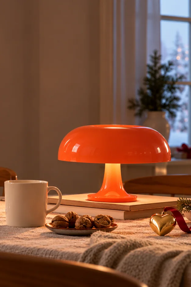 Artemide Nessino in Orange, Teema Tasse und Georg Jensen Herz auf einem weihnachtlich gedeckten Tisch vor dem Fenster